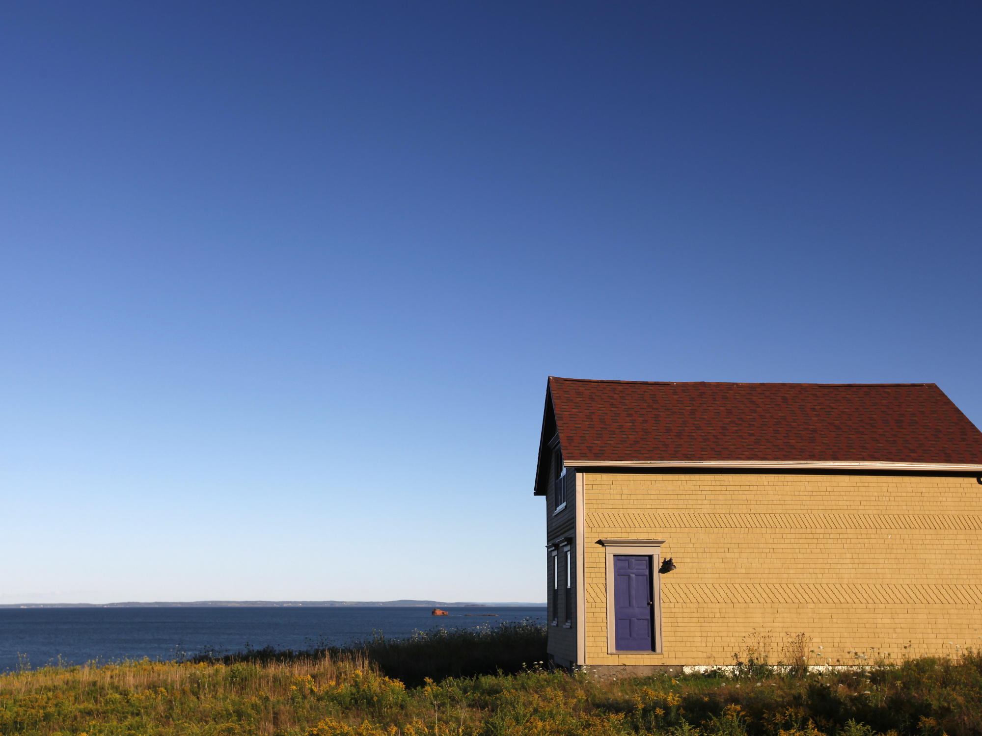 House near a field and blue sky
