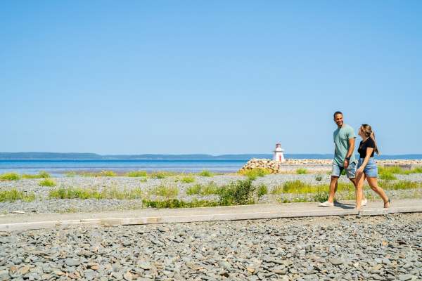 Two people walk along a trail in Belliveau Cove, Nova Scotia